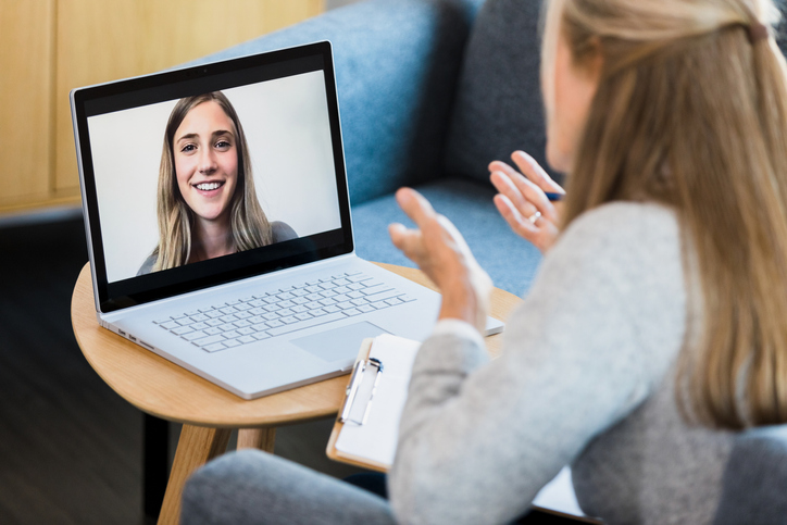 Therapist gives advice to young woman during online therapy session